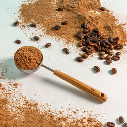 Aura Coffee scoop next to powder and coffee beans